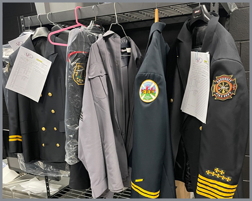 Fire department uniforms hanging on coat rack