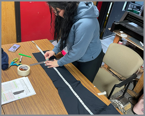 Seamstress measuring pants and marking length